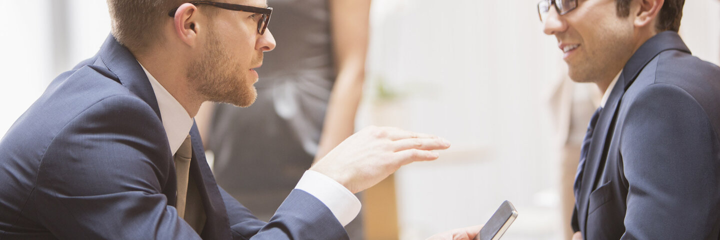 Investor talking to client in open office space.