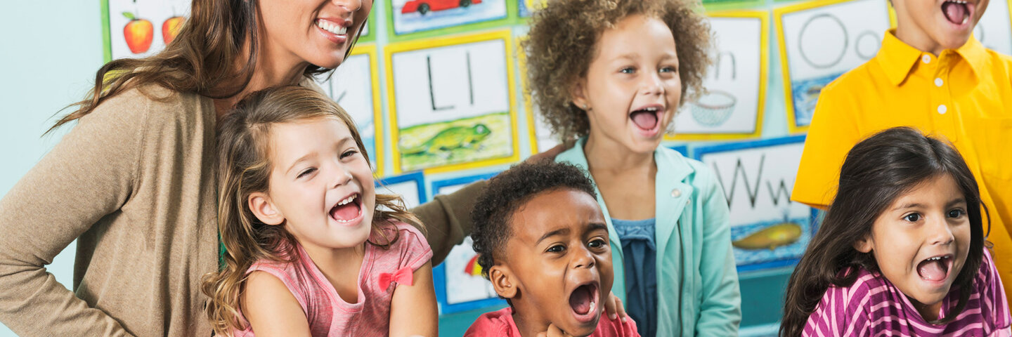 Female teacher encouraging excited elementary students