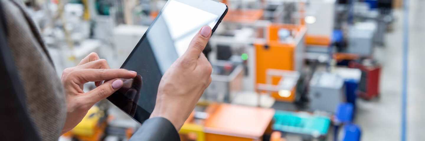 man with tablet overseeing factory