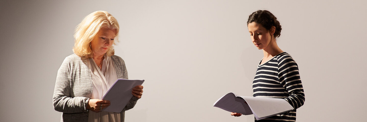 two women reading scripts