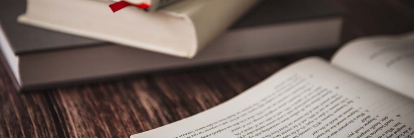 stack of books on a tablenext to an open book