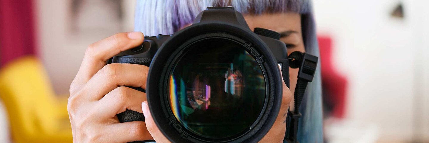 Woman with DSLR camera pointed forward