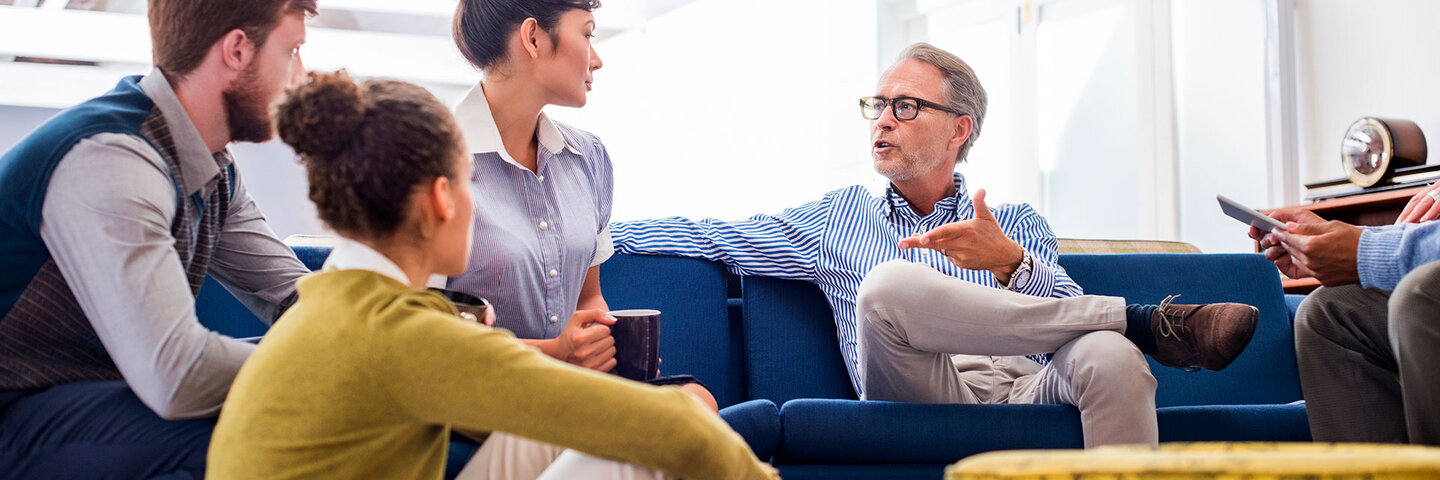 senior leader discussing a topic with younger coworkers