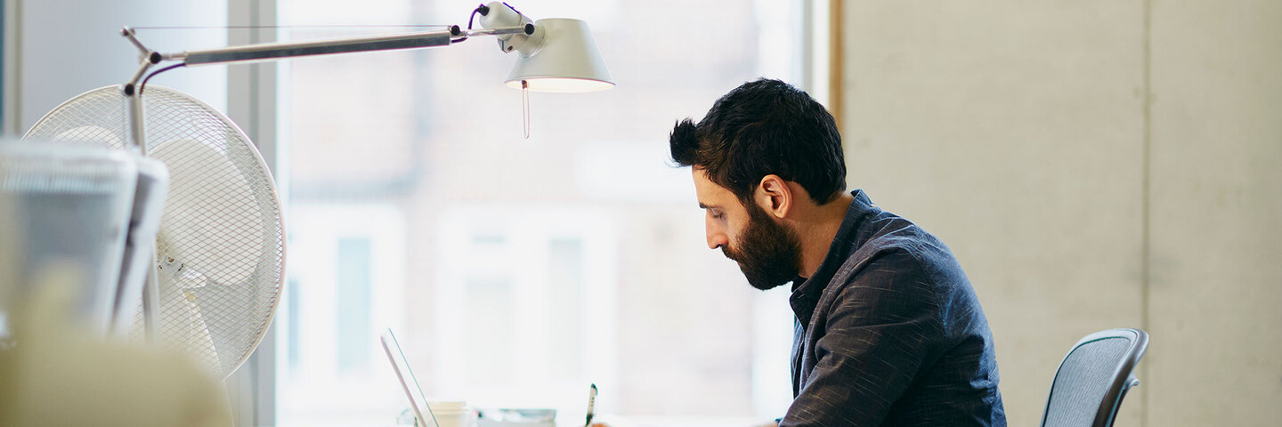Man working at his desk, writing and reading