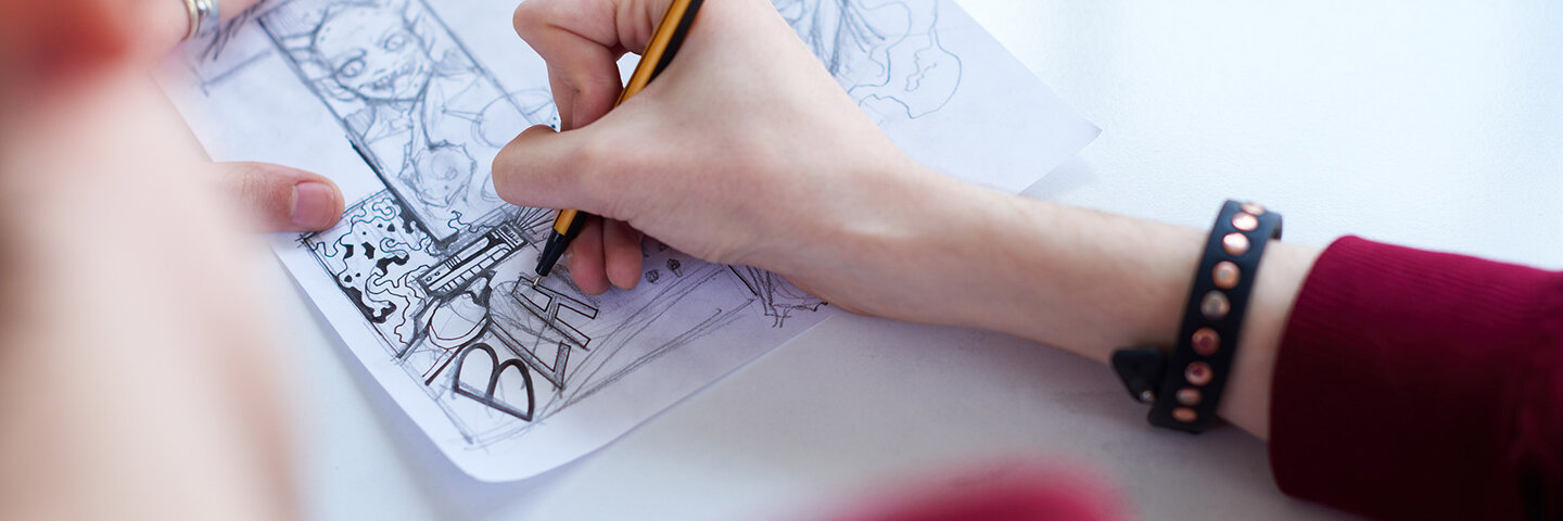 Person illustrating a comic book