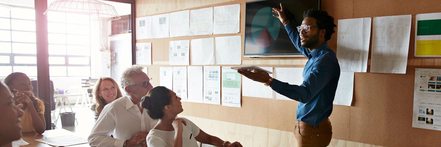 Man doing presentation, using tablet & screen