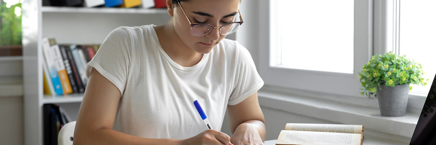 student writing her college entrance exam