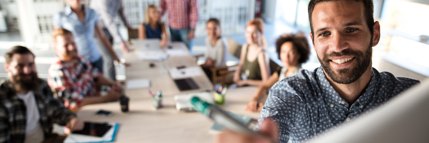 Person writing on the whiteboard in a meeting