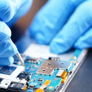 Person with latex gloves working on mobile circuitboard